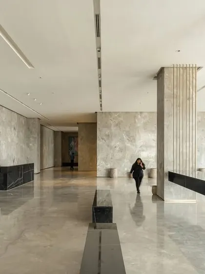 A view of the expansive lobby at One Golden Mile. The design uses a restrained palette of grey marble and black granite, with clean lines and indirect lighting to create a space that feels both grand and tranquil, a refuge from the busy city.
