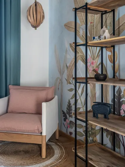 A modern, breezy, and fun daughter's room from the Bombay Blue project. The tropical wallpaper, cane bed, and open shelving create a vibrant and multifunctional space.
