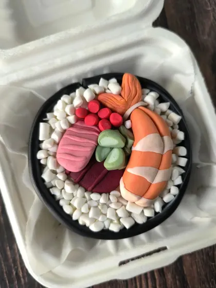 This sushi bento cake is one of my most detailed creations. It looks just like a bowl of chirashi, with fondant shrimp, tuna, and other toppings sculpted to look like the real thing.