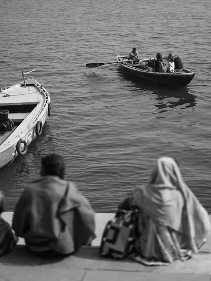 Black and white and color images of people sitting on the ghats, watching the boats go by. These photos capture the contemplative pace of life along the river.