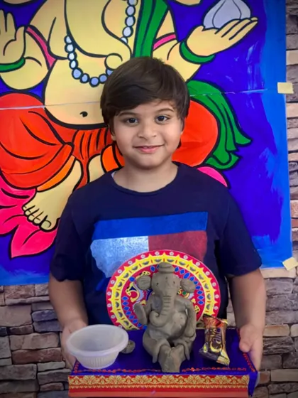 A young artist with his beautifully crafted clay Ganesha. Our workshops provide all the materials and guidance needed for children to create their own festive art, which they can take home for family celebrations.