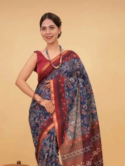 A model in a printed saree wears a matching beaded necklace, showing how to accessorize with bold, colorful pieces.