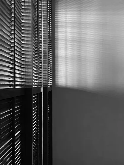 The interplay of light and shadow through wooden blinds in the Worli Duplex. This simple detail creates a beautiful, changing pattern on the walls, adding a sense of dynamism and life to the space.