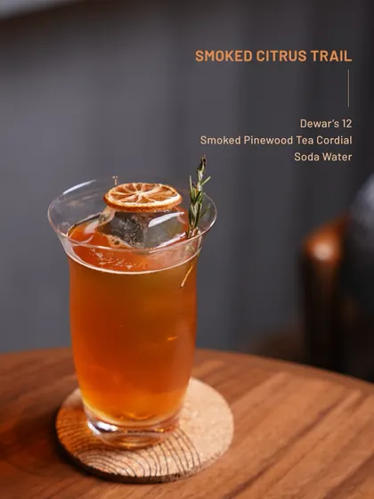 The Smoked Citrus Trail, a cocktail from our Dewar's 12 menu, featuring smoked pinewood tea cordial and soda water.