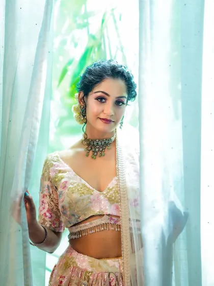 The model peeks through a sheer curtain, creating a soft and dreamy portrait that feels both playful and elegant.