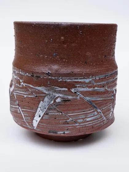 This tea bowl features a dynamic, textured surface. I've carved into the clay and then applied a white slip that breaks and crackles over the lines, adding energy and movement.