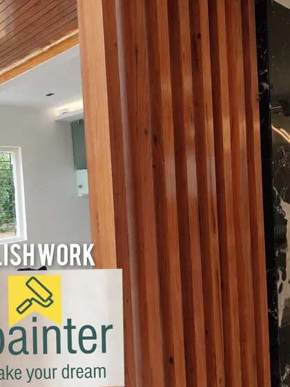 A close-up of a polished wooden slat wall next to a marble-finish wall. The rich color of the wood provides a warm contrast to the stone.