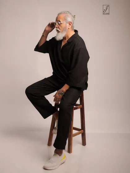Adjusting his glasses, the model adds a touch of personality and intellect to this lifestyle portrait.