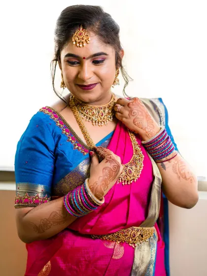 The bride adjusting her beautiful temple jewellery. My makeup application ensures that the focus remains on the bride's happy expression, with a look that enhances rather than overpowers.