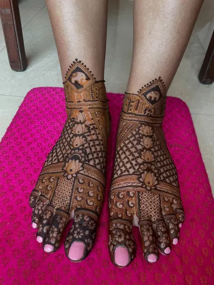 A detailed bridal foot mehendi with elephant motifs and lotus patterns. The design covers the entire foot for a rich and complete bridal look.