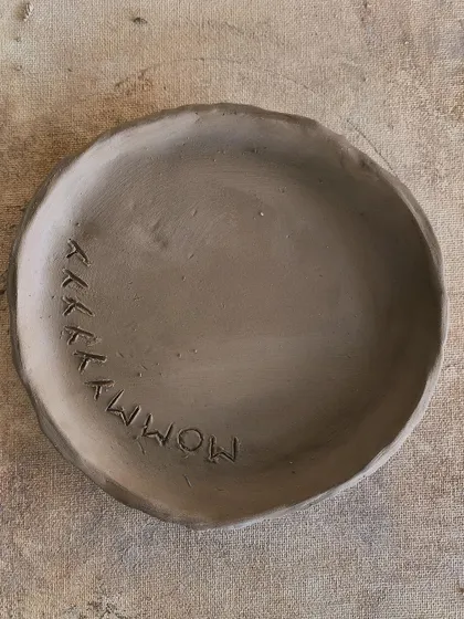 A raw clay plate with 'MOMMY' lovingly stamped into it. A heartfelt piece made for someone special.
