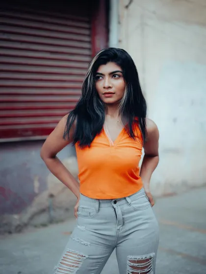 A full-length portrait of a model in a casual yet stylish outfit. The urban background and her confident pose make this a great street style shot.