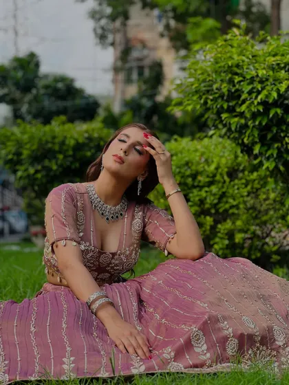 A creative shot of a model in the dusty rose lehenga, perfect for a high-fashion portfolio.