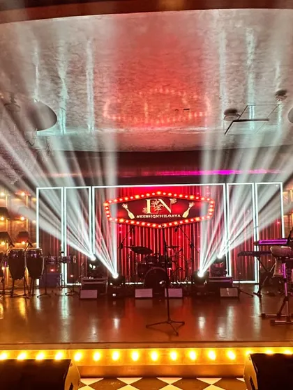 The stage is set for a grand musical performance, with professional lighting rigs and a custom backdrop. This demonstrates my capability to design and execute stages for high-energy entertainment events.