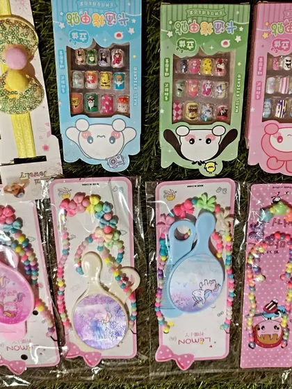 I also have fun items like kids' press on nail sticker sets. This photo shows them alongside other popular return gifts like the mirror and bead sets.