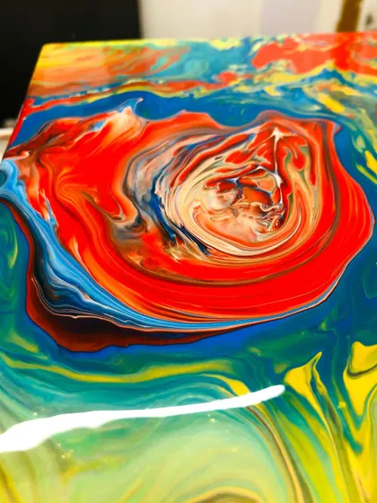 A close up of a fiery red and yellow pour. The patterns resemble a beautiful, swirling vortex of color.