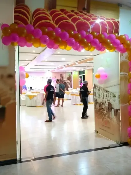 A simple balloon arch is an effective way to welcome guests and set a festive mood right from the entrance of the party hall. This one uses a classic pink and gold color combination.