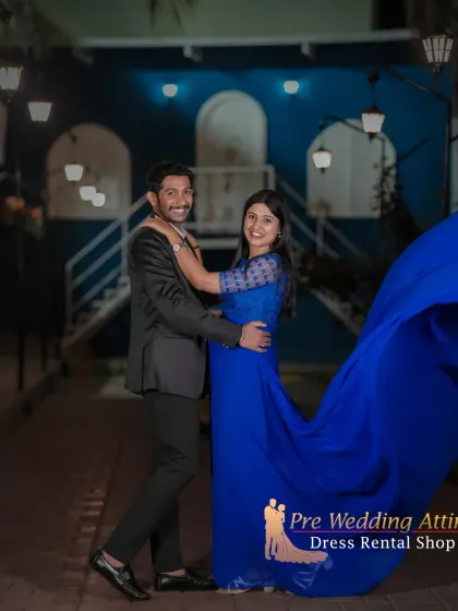 A candid moment between a couple in a coordinated blue gown and black suit. This demonstrates how my outfits are comfortable enough for natural interactions and movement during your shoot.