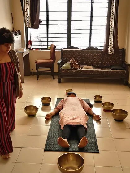 A student practices creating a sound field around a participant lying in Savasana. You will learn how to arrange and play the bowls to create an immersive and deeply relaxing sound bath experience.