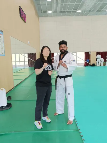 Posing with a talented black belt practitioner from another country, sharing our mutual passion for Taekwondo.