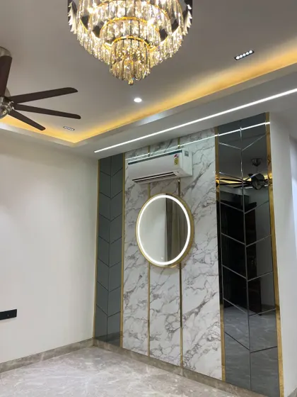 A close-up of the accent wall, showing the beautiful crystal chandelier and the reflection in the mirror panels.