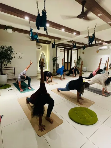 Students hold a lunge pose, their strong and stable forms filling the studio.