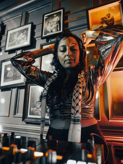 A DJ with undeniable stage presence, commanding the room with her set.