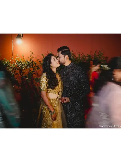 A candid kiss amidst the motion-blurred crowd, freezing a private moment in a public celebration.