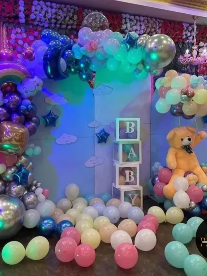 A whimsical "Oh Baby" setup with a rainbow, clouds, and a teddy bear. The pastel balloons and "BABY" blocks make this a perfect backdrop for a baby shower.