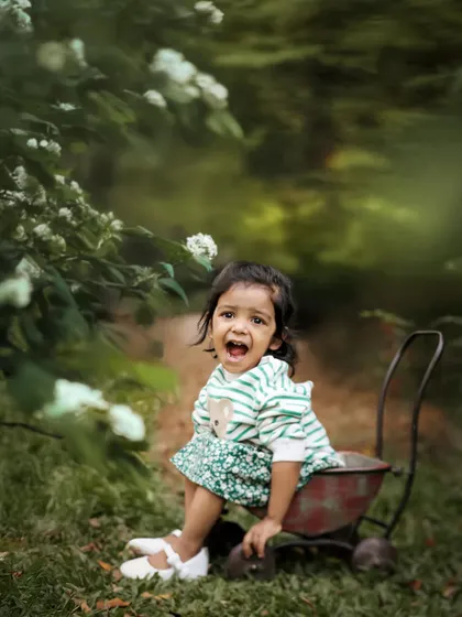 A candid and expressive moment captured in the wildness of the garden. This toddler's spontaneous reaction makes for a real and memorable photograph.