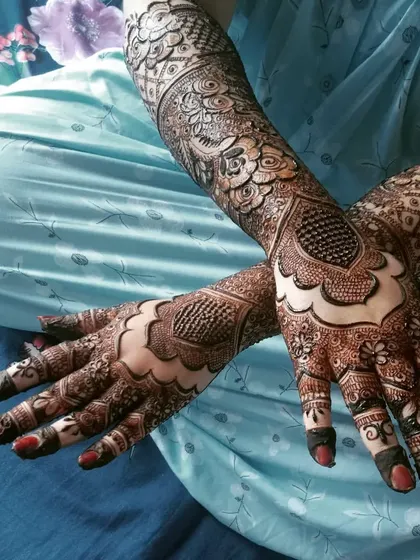 This beautiful engagement henna features a bold geometric pattern on the back of the hands, complemented by intricate details on the fingers and arms.