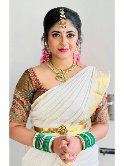 Another angle of the classic white and gold saree look, showing the beautiful makeup and hair.