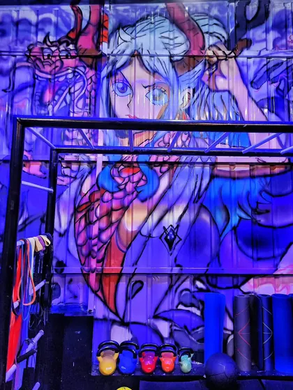 The Yamato mural seen under dramatic purple lighting, which enhances the colors and makes the character stand out.