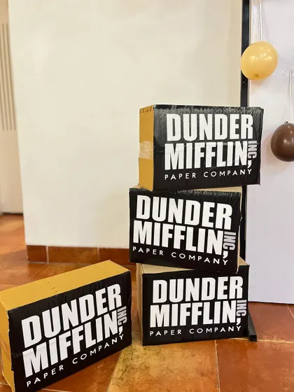 The 'Dunder Mifflin' party entrance featured a welcome sign from the "party planning committee" and stacks of branded paper boxes, setting the tone for 'The Office' theme.