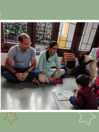 Parents listen intently as their son explains the parts of a leaf using a botany puzzle. This is a beautiful example of how our curriculum connects children to the natural world.