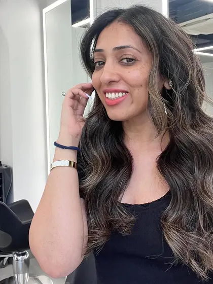 A happy client showing off her new signature balayage. The color is natural, dimensional, and perfectly suited to her.