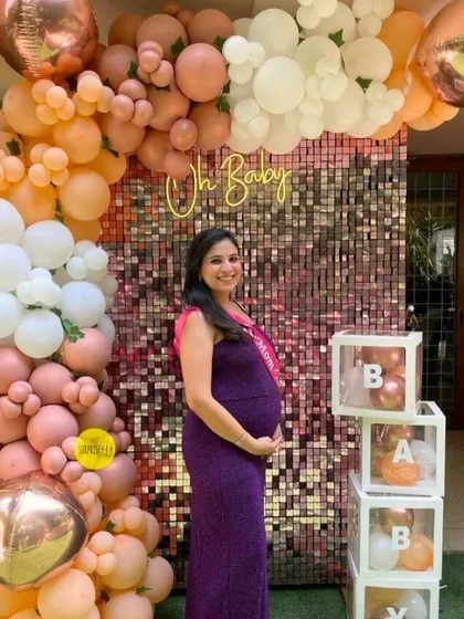 A glowing mom-to-be at her baby shower. Our rose gold sequin wall with a pastel organic balloon arch and "BABY" blocks created the perfect, shimmery backdrop for her to capture these precious memories.