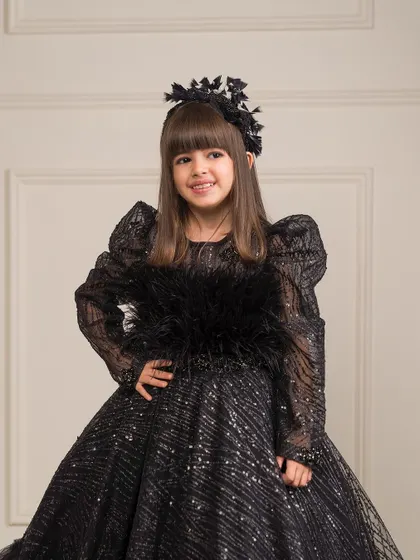 A closer look at the luxurious feather and sequin detailing on the bodice of our black ball gown.