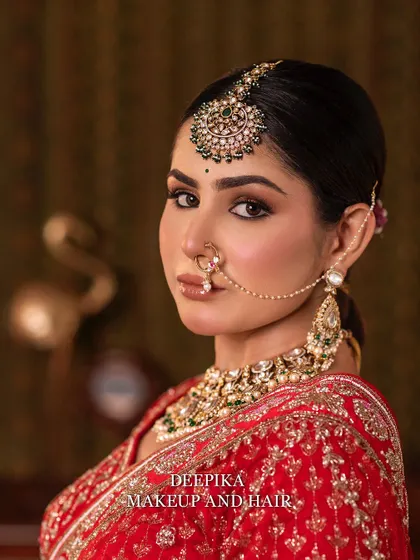 A close-up of the bride, focusing on her stunning eye makeup and the traditional nath (nose ring). The contouring is sharp and defines her features beautifully.