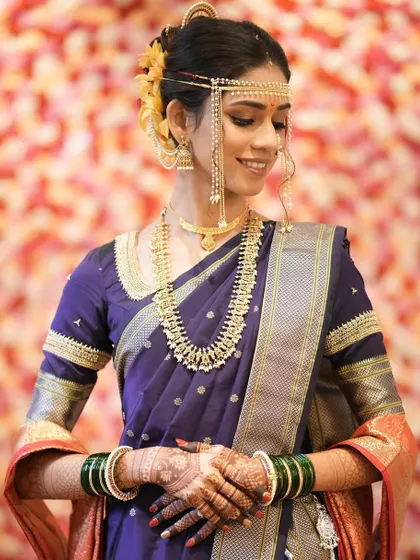 Elegance personified. This bride's traditional look in a purple Nauvari saree is enhanced with subtle makeup and classic Maharashtrian jewelry.