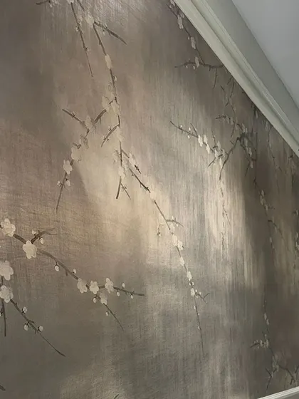 A close-up of the hand-painted, silver-leafed wallpaper used in the jewelry store project. The delicate cherry blossoms and shimmering background exude a timeless elegance that enhances the luxury of the space.
