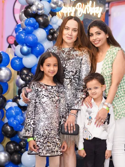 A family poses for a stylish photo against a beautiful balloon backdrop.