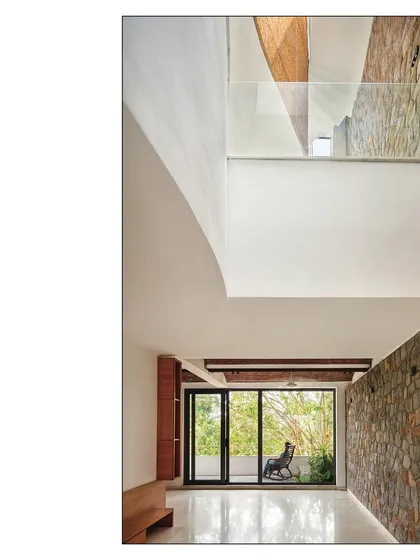 This image captures the feeling of wonder in the space, with its soaring volumes, natural light, and the contrast between raw stone and smooth white walls.