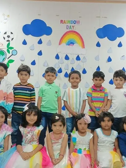A class of preschoolers in their colorful dresses and outfits, celebrating Rainbow Day with joy.