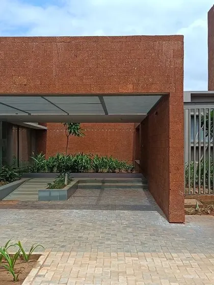 The entrance to a block at the Bagchi Karunashraya hospice, where a covered walkway provides a transition from the open landscaped areas to the building interior.