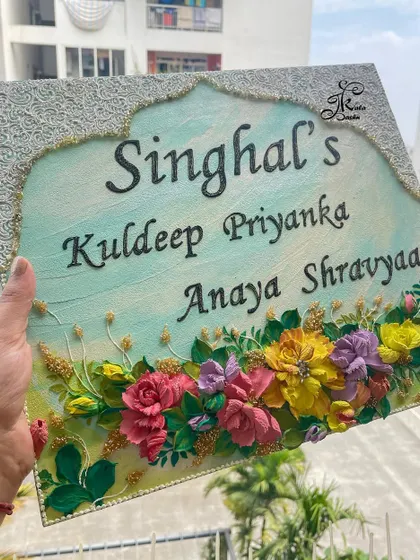 Holding the "Singhal" family nameplate outdoors, showing how the colors and textures look in natural sunlight.