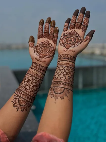 A closer view of the mandala design, showing the intricate details on the fingers and the geometric bands on the forearms.
