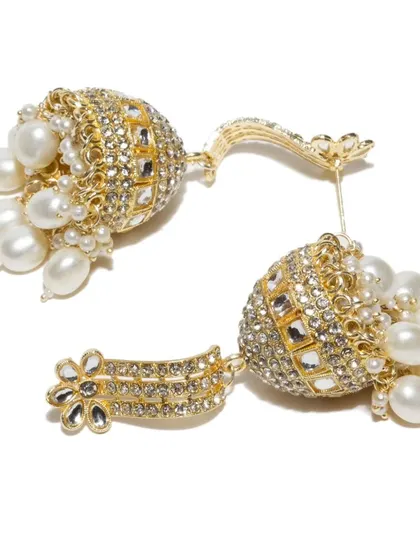 A detailed shot of the pearl kundan jhumkas, highlighting the quality of the pearls and the sparkle of the stones.