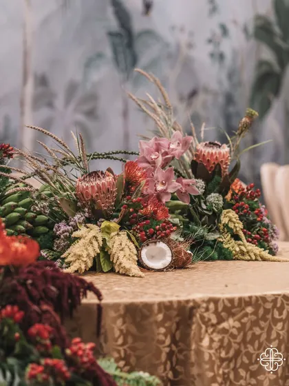 A close-up of a tablescape from the 'Orchard of Life' event, featuring coconuts and other tropical elements.