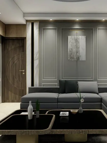 This design demonstrates a perfect fusion of classical and modern interior styles. The wall is treated with traditional panel mouldings but finished in a contemporary grey, while the sleek, low-profile sectional sofa maintains a modern sensibility.